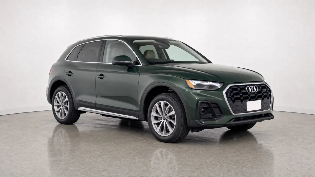 Dark green SUV in a neutral dealer studio, photographed from the opposite front three-quarter angle