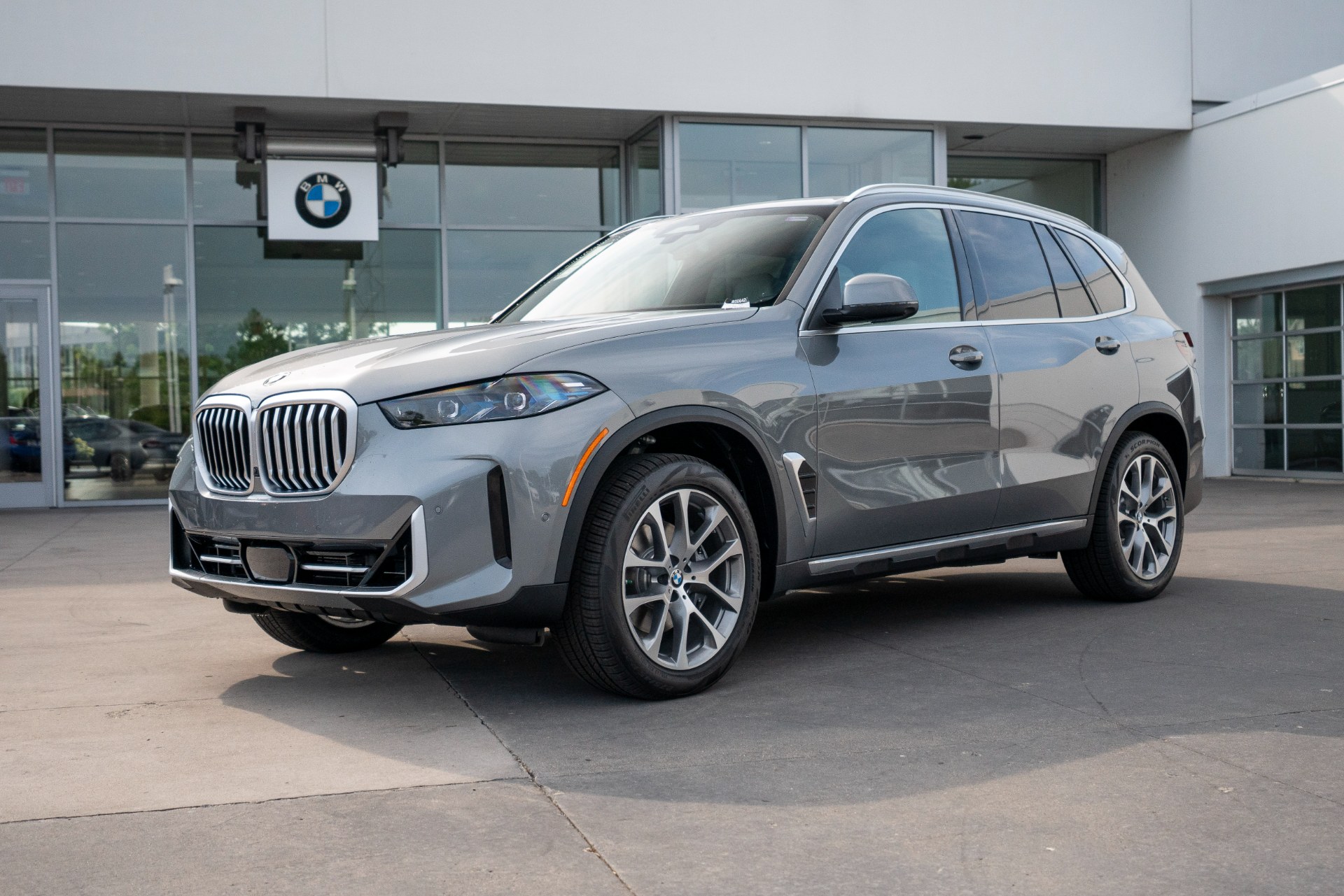 Silver SUV photographed outside a dealership before background removal