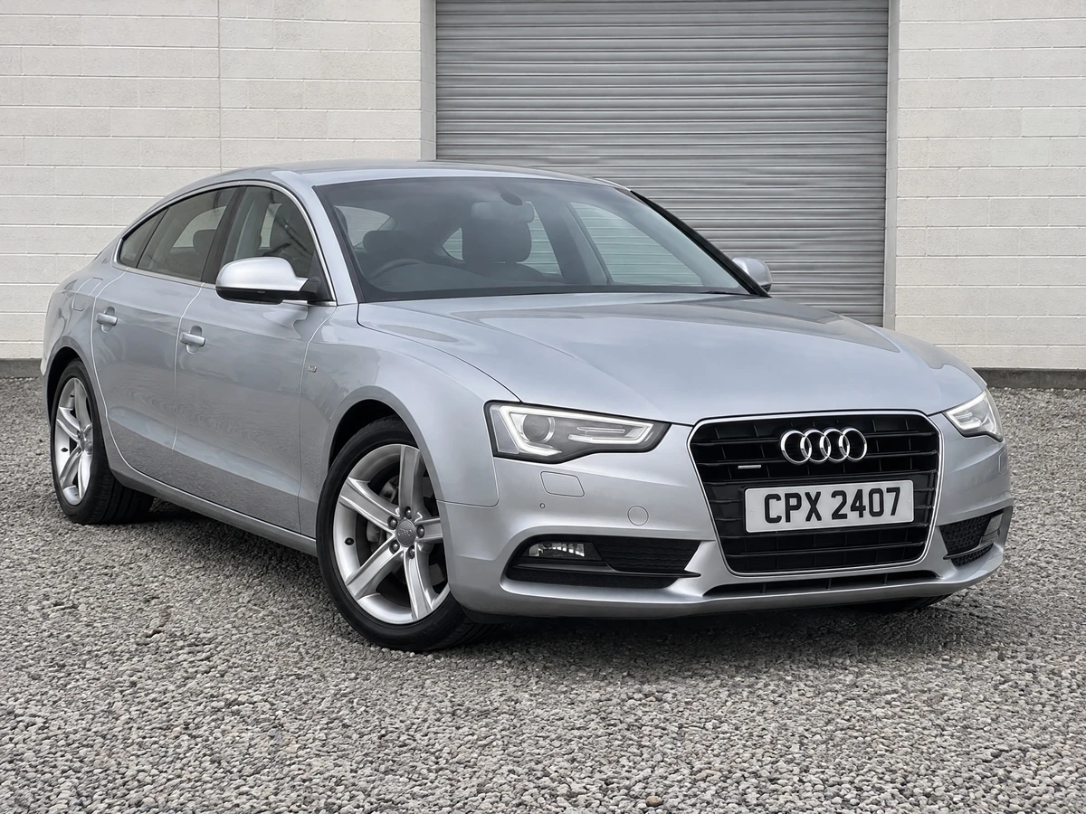 Silver Audi A5 Sportback photographed on a gravel dealership service yard with a CPX 2407 plate
